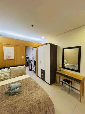 a bedroom with a bed and a desk and a mirror at Sunvalley B&b in Manila