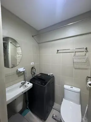 a bathroom with a toilet and a sink and a mirror at FAME RESIDENCES CONDO-TEL Near EDSA Shang in Manila