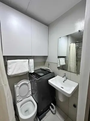 a small bathroom with a toilet and a sink at Eu & El Condo in Manila