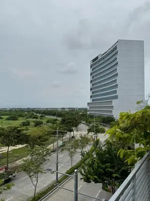a tall white building with a parking lot at Maple Grove Yasuragi Stay in General Trias