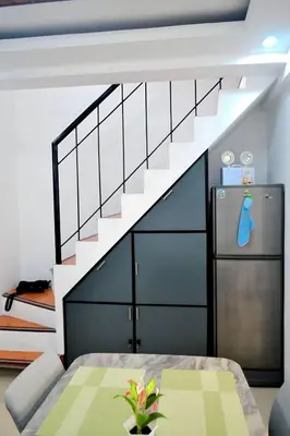 a living room with a staircase and a refrigerator at Auntie's in Tanza