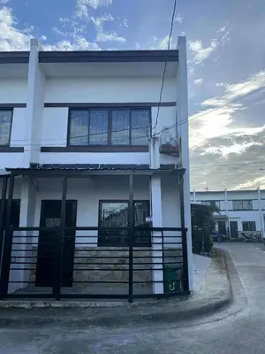 a white building with a balcony on the side of it at Auntie's in Tanza