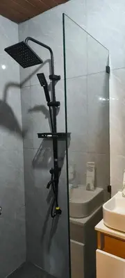 a bathroom with a glass shower with a sink at Auntie's in Tanza