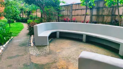 a bench sitting in a yard with a fence at Cozy Corner at Paseo Verde with Free On-Site Private Parking in Manila