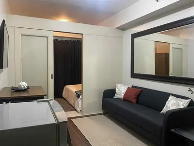 a living room with a couch and a bedroom at Sea Residences Tower F in Manila