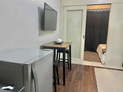 a small kitchen with a table and a room with a bed at Sea Residences Tower F in Manila