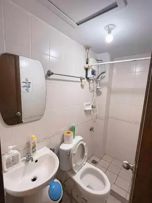 a small bathroom with a toilet and a sink at Isabelle Garden Hotel & Suites in Manila