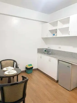 a small kitchen with a table and chairs and a counter at Isabelle Garden Hotel & Suites in Manila