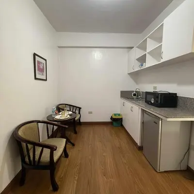 a small kitchen with a table and chairs in a room at Isabelle Garden Hotel & Suites in Manila