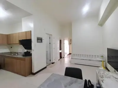 a large white kitchen with a table and a bed at fairlane residences in Manila
