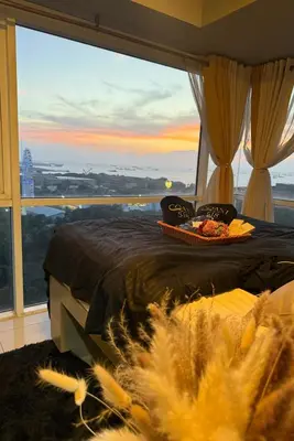 a bedroom with a bed and a large window at COAST518 Pasay in Manila