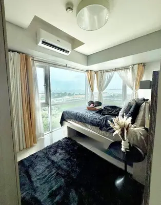 a bedroom with a bed and a large window at COAST518 Pasay in Manila