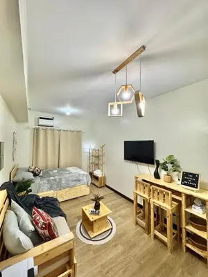 a living room with a bed and a tv at The Stayhaus by Dan & Steph in Manila