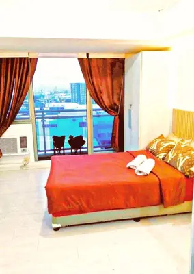 a bedroom with a large bed and a large window at Azure Paris Hilton Resort and hotel 1 bedroom for 4pax in Manila