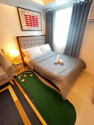 a bedroom with a bed with slippers on it at Light Lux in Manila