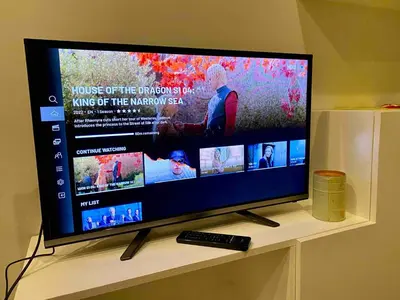 a television sitting on a table with a remote control at Affordable Nordic Style Condo in Makati in Manila