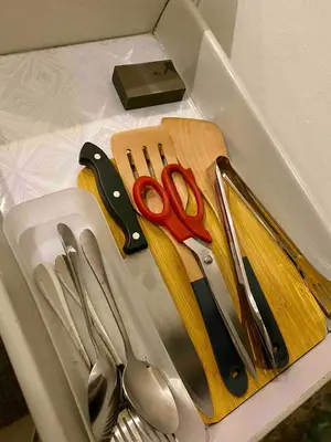 a box filled with scissors and other kitchen utensils at Affordable Nordic Style Condo in Makati in Manila