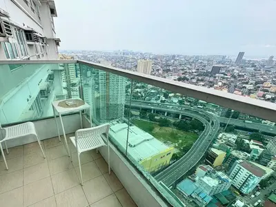 a balcony of a building with a view of a city at Cozy Condo at MakatiCBD in Manila
