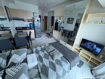 a bedroom with a large bed and a living room at Cozy Condo at MakatiCBD in Manila