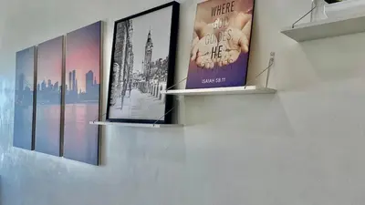 a wall with three shelves with posters on it at High End Penthouse Makati CBD in Manila