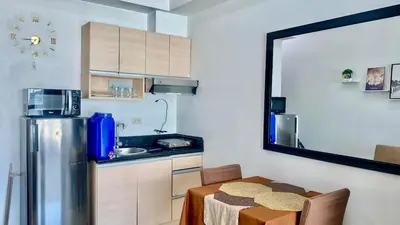 a small kitchen with a table and a refrigerator at High End Penthouse Makati CBD in Manila