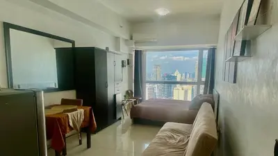 a bedroom with a bed and a view of a city at High End Penthouse Makati CBD in Manila