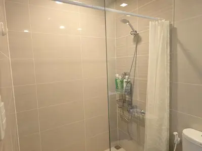 a bathroom with a shower with a glass door at Beautiful Sunset One Uptown near Grand Hyatt BGC Uptown, St Lukes Medical Center, and Mitsukoshi Mall in Manila