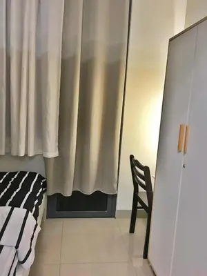 a bedroom with a bed and a chair and a curtain at Cloud 1979 at Shore 2 Tower 2 in Manila