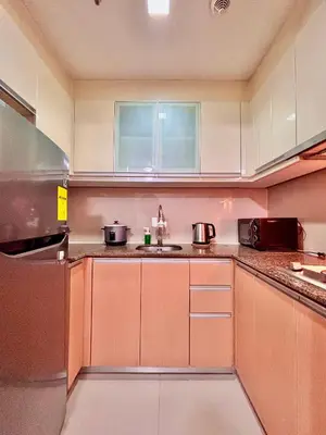 a kitchen with brown cabinets and a sink at Big Studio Unit in Newport near NAIA w Balcony in Manila