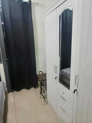 a bedroom with a bed and a closet with a mirror at Manial Mall of Asia 1 Bedroom Shore 2 Residence in Manila