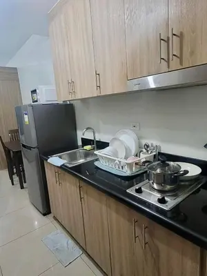 a kitchen with a stove and a sink and a refrigerator at Manial Mall of Asia 1 Bedroom Shore 2 Residence in Manila