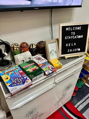 a shelf with books and a sign on it at Staycation ni Gelo in Manila