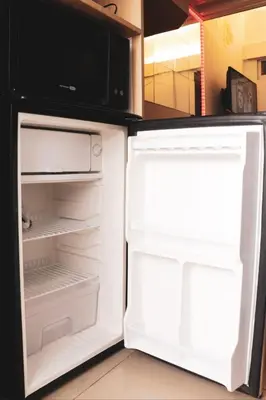 an empty refrigerator with its door open in a kitchen at Cozy and Affordable Loft Condo in Manila Center in Manila