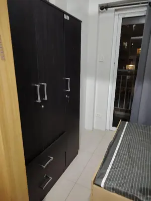 a room with black cabinets and a bed in it at AteAbyPlace648 in Manila