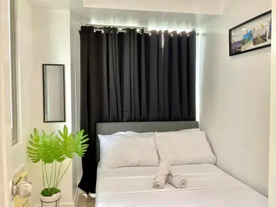 a bedroom with a bed with a black curtain at MG Labels Property in Manila