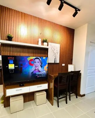 a living room with a television and a table with chairs at NEW 2-Bedroom 2-Bath Condo - Flair Towers, near Greenfield District, Ortigas in Manila