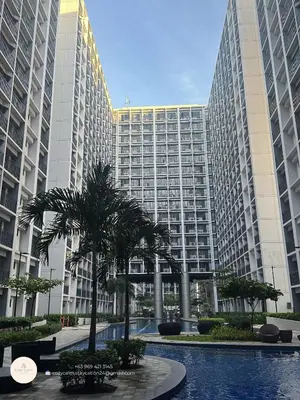 a large building with palm trees in front of it at CozyCalmStaycation in Manila