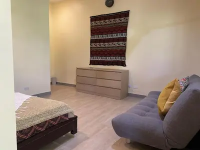 a living room with a couch and a bed at Tagaytay Foothills Cherimoya Farm - Pugad 2 in Calamba