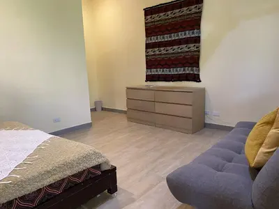 a bedroom with a bed and a dresser and a window at Tagaytay Foothills Cherimoya Farm - Pugad 2 in Calamba