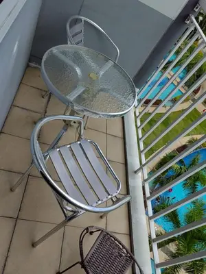 a glass table sitting on the floor next to a staircase at Apartment Shell Residences near MOA in Manila