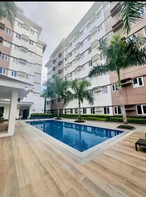 a swimming pool in front of a building at G-VibeZzz Staycation in Trece Martires