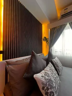 a room with a couch with pillows and a window at Zhafira Retreat in Manila
