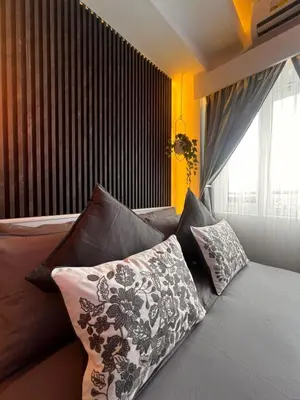 a room with a couch with pillows and a window at Zhafira Retreat in Manila