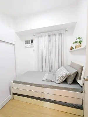 a bed in a room with a window at Friends Zone - 2BR condo unit in Mandaluyong in Manila