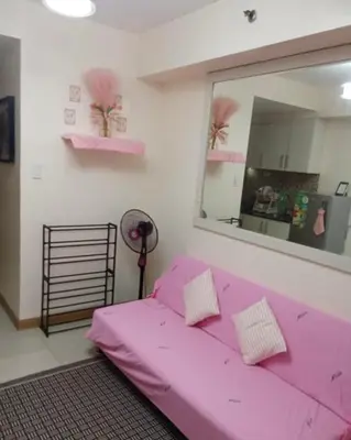 a pink bed in a room with a mirror at 10th Floor Staycation in Manila