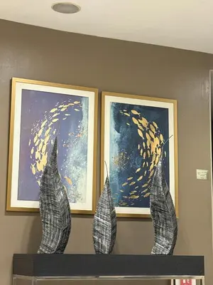 two paintings on a wall with two vases on a shelf at 10th Floor Staycation in Manila
