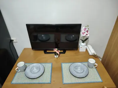 a wooden table with two plates and mugs on it at AteAbyPlace830 in Manila