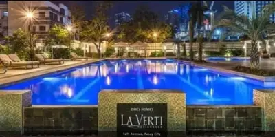a large swimming pool with blue water at night at 1BR LaVerti Cloud Nine Suite Family affordable staycation in Manila