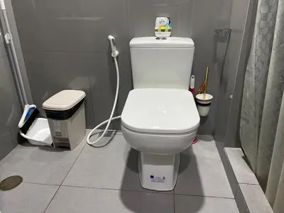 a white toilet in a bathroom with a hose at Sunrise Haven in Makati AIR Residences in Manila