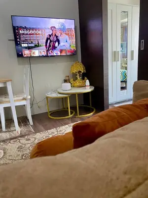 a living room with a tv and a table at Sunrise Haven in Makati AIR Residences in Manila